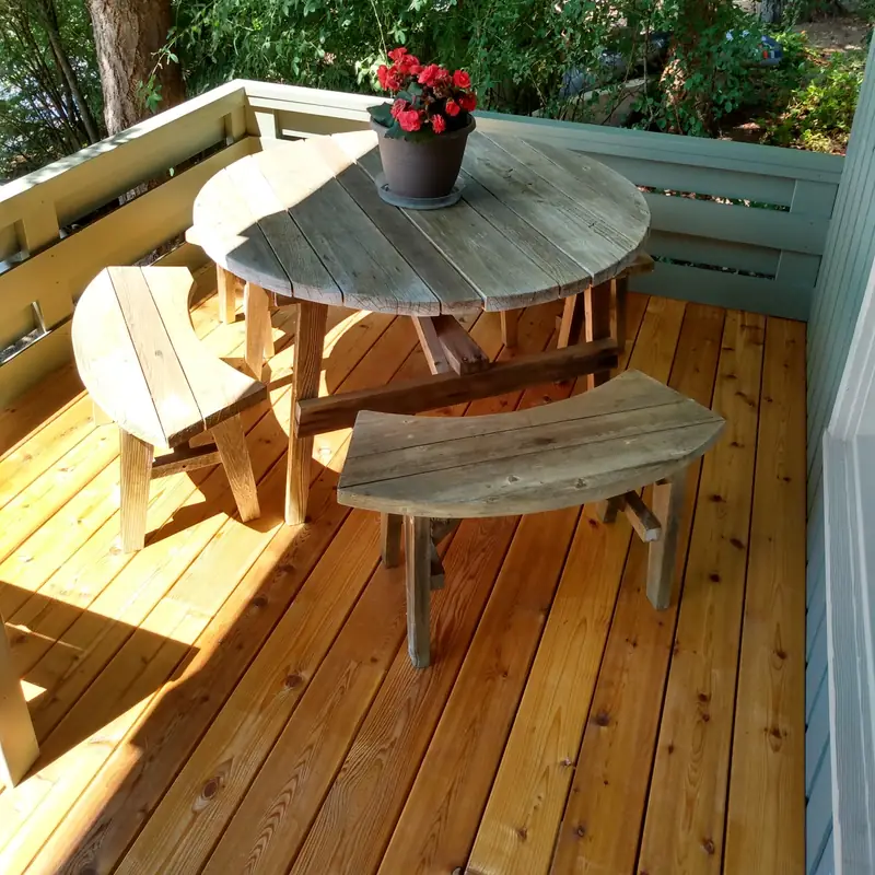 Stained cedar deck with a round table and flowers